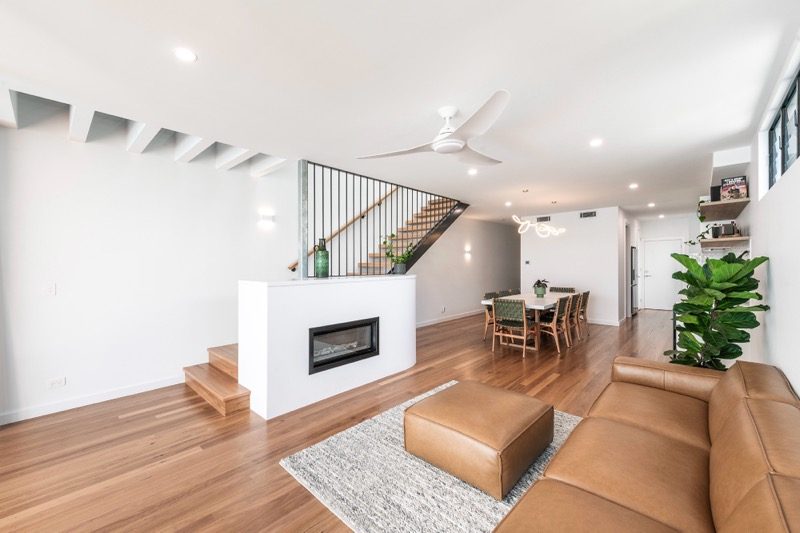 Living area with built-in fireplace, leather sofa and timber floors