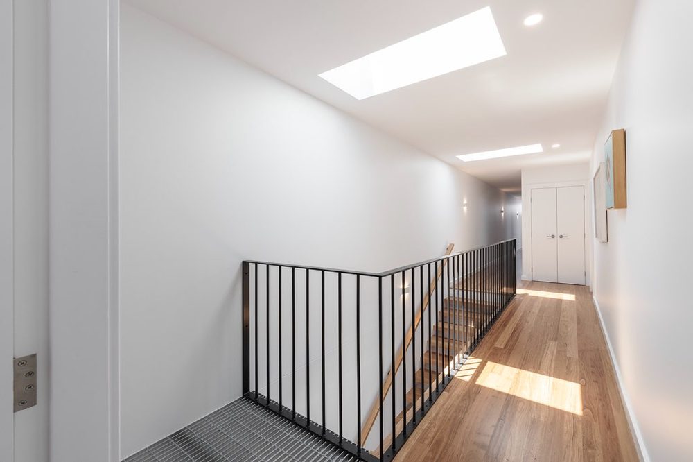 Hallway with skylight, timber floor and black steel balustrade