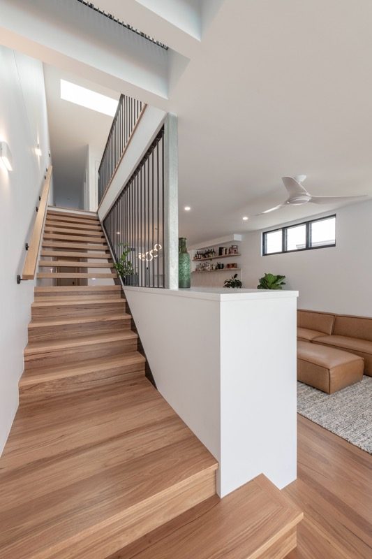 Timber staircase leading to a lounge with leather seating