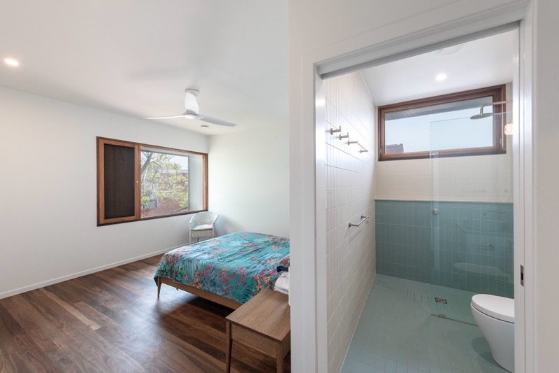 Bedroom with adjoining ensuite featuring sage green tiling