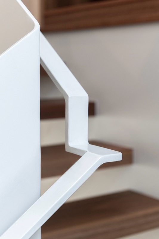 Detail of a crisp white-painted staircase handrail
