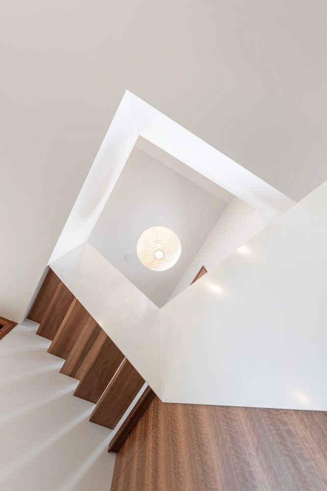 Stairwell void with white walls and timber treads